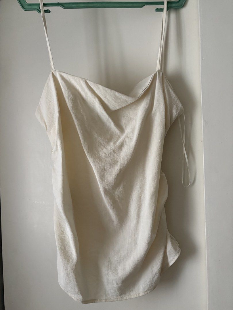 Mango Cream Camisole Top Size M (Category: Sleeveless) located in Pasig City. Submitted by makeuplover219 (Listing ID 1469437022, Image 1). Description: - Brand: MNG Mango - Size: Medium (M) - Color: Cream - Design: low neckline with thin spaghetti straps and ruched side detail - Versatile piece, easy to dress up or down - SF: c/o buyer Grab, Gogo Express, and Lalamove.
