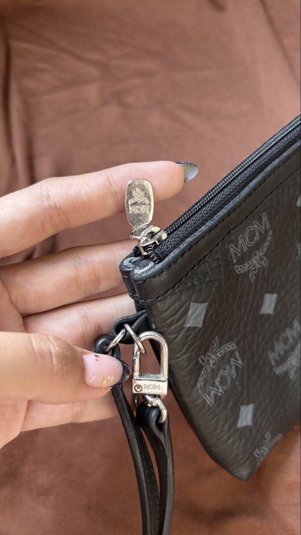 MCM Black Monogram Leather Wristlet Clutch (Category: Luxury Bags & Wallets) located in Taguig. Submitted by awatc_hes (Listing ID 1469446684, Image 3). Description: - Authentic Black MCM monogram leather wristlet - Secure zip-top closure with sleek silver-tone hardware - Versatile design with a removable wrist strap - Clean interior lining featuring a spacious open main compartment - Compact and lightweight, perfect for carrying your daily essen