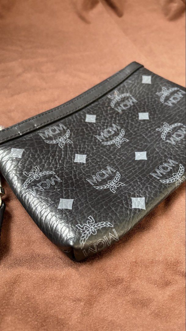 MCM Black Monogram Leather Wristlet Clutch (Category: Luxury Bags & Wallets) located in Taguig. Submitted by awatc_hes (Listing ID 1469446684, Image 2). Description: - Authentic Black MCM monogram leather wristlet - Secure zip-top closure with sleek silver-tone hardware - Versatile design with a removable wrist strap - Clean interior lining featuring a spacious open main compartment - Compact and lightweight, perfect for carrying your daily essen