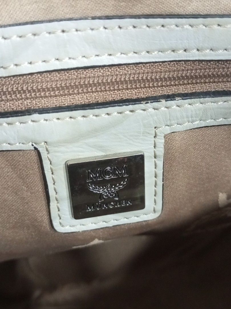 MCM München Visetos Monogram Satchel Handbag (Category: Luxury Bags & Wallets) located in Bacolod City. Submitted by exequelgra46775 (Listing ID 1469425085, Image 3). Description: - Authentic MCM München handbag in classic monogram print - Cream leather trim with double top handles - Multiple stylish buckled exterior pockets - Silver-tone hardware with smooth YKK zippers - Clean interior with MCM logo pattern lining and a zippered pocket - Includ