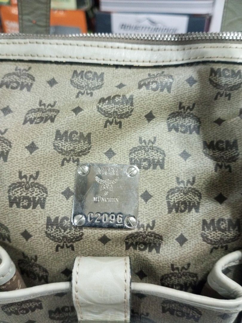 MCM München Visetos Monogram Satchel Handbag (Category: Luxury Bags & Wallets) located in Bacolod City. Submitted by exequelgra46775 (Listing ID 1469425085, Image 2). Description: - Authentic MCM München handbag in classic monogram print - Cream leather trim with double top handles - Multiple stylish buckled exterior pockets - Silver-tone hardware with smooth YKK zippers - Clean interior with MCM logo pattern lining and a zippered pocket - Includ