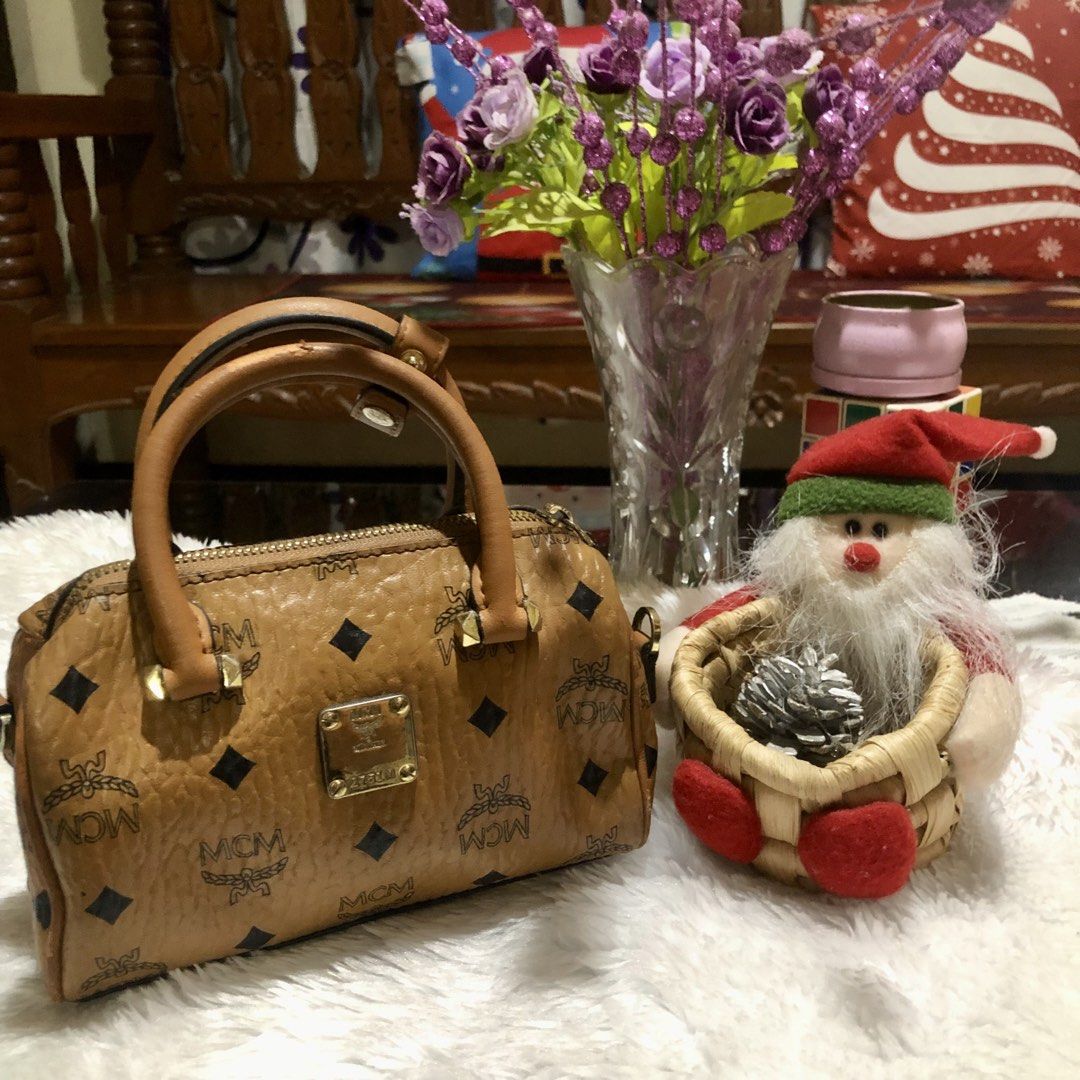 MCM Monogram Boston Bag (Category: Luxury Bags & Wallets) located in Meycauayan. Submitted by miletteaqu82717 (Listing ID 1469415574, Image 1). Description: - Brand: MCM - Style: Boston Bag - Color/Pattern: Classic Brown Monogram - Hardware: Gold-tone with front metal plaque - Straps: Dual top handles & detachable shoulder strap - Closure: Top zipper - Interior: Fabric-lined with 1 slip pocket - Mode of Payment: thru GCash.