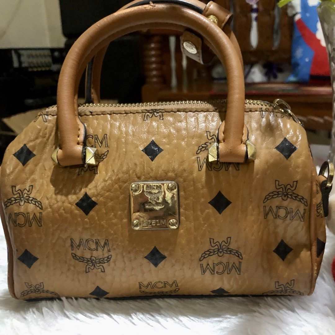 MCM Monogram Boston Bag (Category: Luxury Bags & Wallets) located in Meycauayan. Submitted by miletteaqu82717 (Listing ID 1469415574, Image 2). Description: - Brand: MCM - Style: Boston Bag - Color/Pattern: Classic Brown Monogram - Hardware: Gold-tone with front metal plaque - Straps: Dual top handles & detachable shoulder strap - Closure: Top zipper - Interior: Fabric-lined with 1 slip pocket - Mode of Payment: thru GCash.