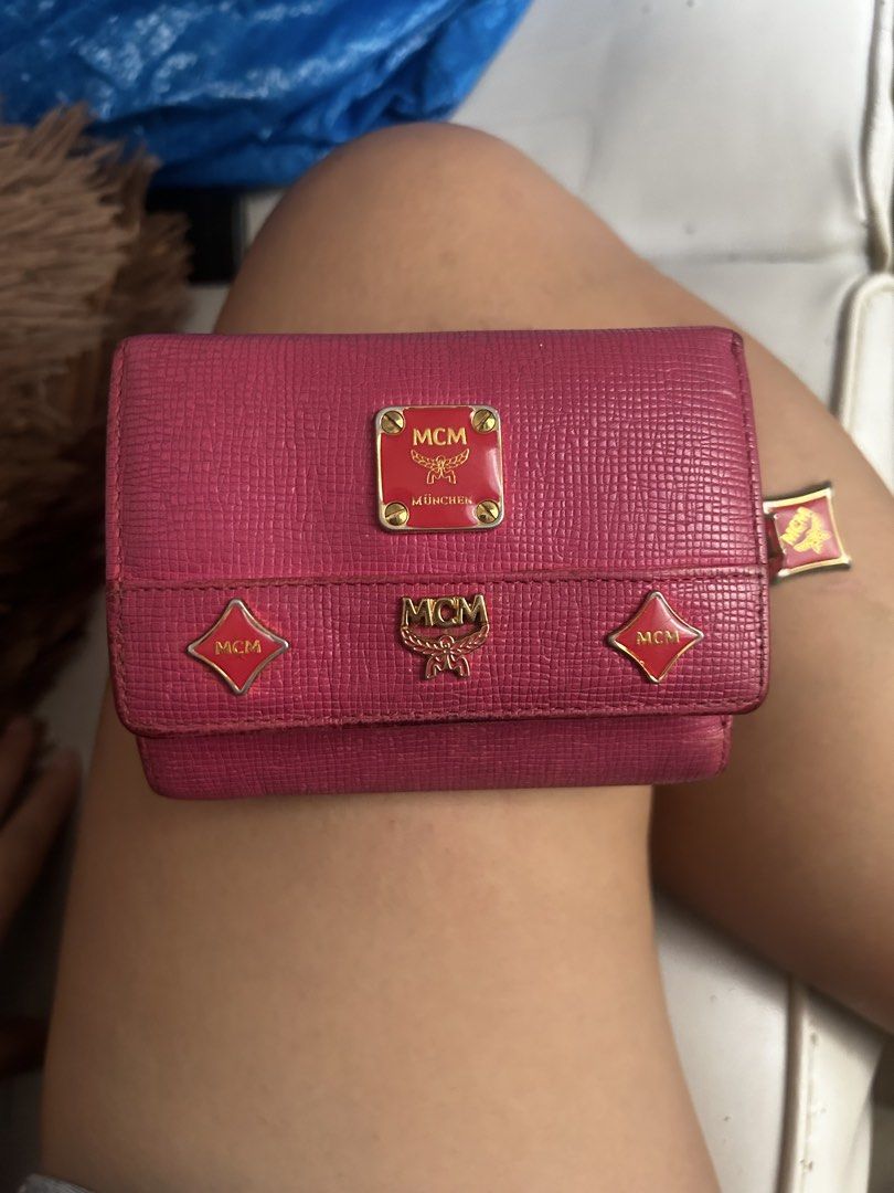 MCM Pink Leather Trifold Wallet (Category: Luxury Bags & Wallets) located in Cebu City. Submitted by yenetcuba52435 (Listing ID 1469507950, Image 2). Description: - Brand: MCM - Material: 100% Cow leather - Color: Pink with gold-tone hardware and red enamel accents - Design: Trifold wallet with multiple card slots, cash compartment, and ID window - Extras: Attached side chain charm with MCM logo - Inclusions: Original tag and care booklet - Condi