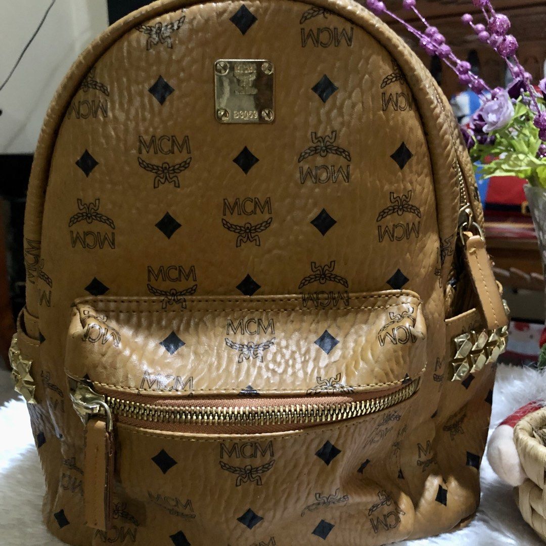 MCM Visetos Monogram Studded Backpack Cognac (Category: Luxury Bags & Wallets) located in Meycauayan. Submitted by miletteaqu82717 (Listing ID 1469415794, Image 2). Description: - MCM backpack in the iconic cognac Visetos monogram print - Features a secure front zip pocket and convenient side slip pockets with edgy pyramid stud detailing - Equipped with comfortable adjustable shoulder straps and a top grab handle - Accented with luxurious gold-to