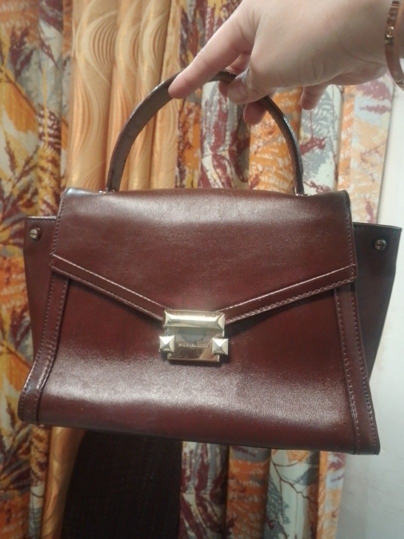 Michael Kors Brown Leather Top Handle Handbag (Category: Luxury Bags & Wallets) located in Manila. Submitted by annemil_1984 (Listing ID 1469451372, Image 1). Description: - Brand: Michael Kors - Color/Material: Rich brown leather - Style: Structured trapezoid top handle bag with a flap closure - Hardware: Gold-tone geometric metal clasp with visible scuffs - Condition: Minor surface marks on the leather body, hardware shows wear - Features: Sing