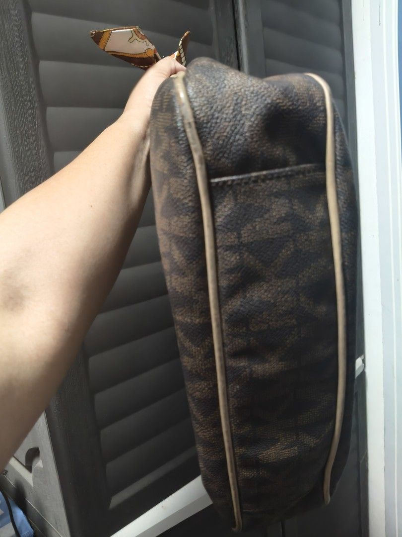 Michael Kors Brown Monogram Hobo Shoulder Bag (Category: Shoulder Bags) located in Manila. Submitted by stuff_finder (Listing ID 1469424113, Image 2). Description: - Brand: Michael Kors - Material: Brown monogram canvas with beige leather trim - Hardware: Gold-tone with engraved front logo plaque - Accents: Includes a stylish printed twilly scarf tied to the strap rings - Interior: Multiple compartments, zip pockets, and clean MK logo-patterned l