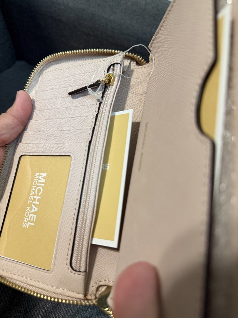 Michael Kors Leather Wristlet Wallet Pink (Category: Wallets & Card holders) located in Quezon City. Submitted by pam07pam (Listing ID 1469482104, Image 3). Description: - Authentic pink Michael Kors wristlet wallet in premium textured leather - Secure zip-around closure with a matching detachable wrist strap - Elegant gold-tone hardware and front logo lettering - Organized interior with multiple card slots, slip pockets, and a zippered coin comp