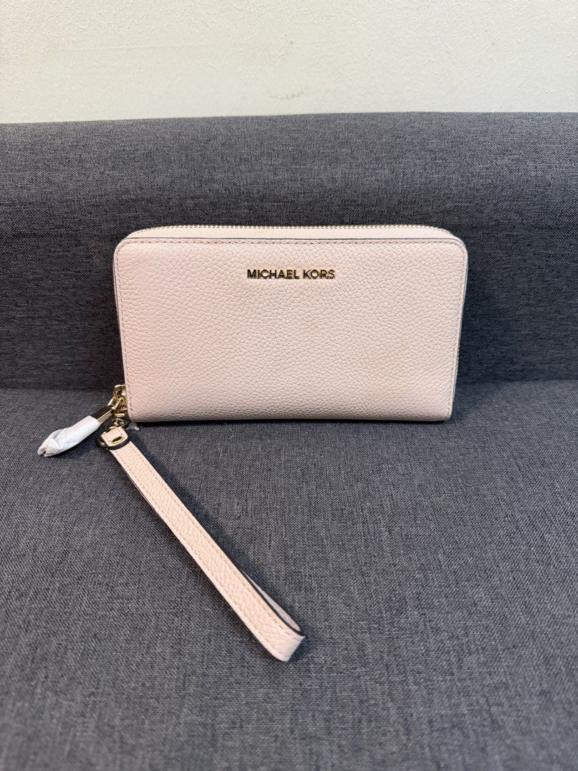 Michael Kors Leather Wristlet Wallet Pink (Category: Wallets & Card holders) located in Quezon City. Submitted by pam07pam (Listing ID 1469482104, Image 1). Description: - Authentic pink Michael Kors wristlet wallet in premium textured leather - Secure zip-around closure with a matching detachable wrist strap - Elegant gold-tone hardware and front logo lettering - Organized interior with multiple card slots, slip pockets, and a zippered coin comp