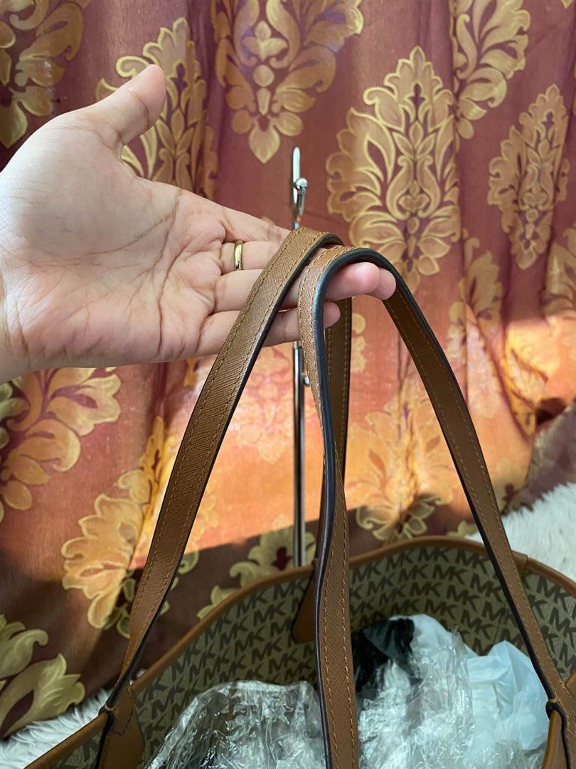 Michael Kors reversible brown MK monogram tote bag (Category: Tote Bags) located in Manila. Submitted by melissatua68314 (Listing ID 1469517335, Image 3). Description: - Michael Kors reversible tote bag - Design 1: Classic all-over MK signature monogram pattern - Design 2: Solid brown Saffiano leather look - Dual top handles for comfortable shoulder wear - Elegant gold-tone MK metal logo plaque - Spacious interior, perfect for everyday essentials