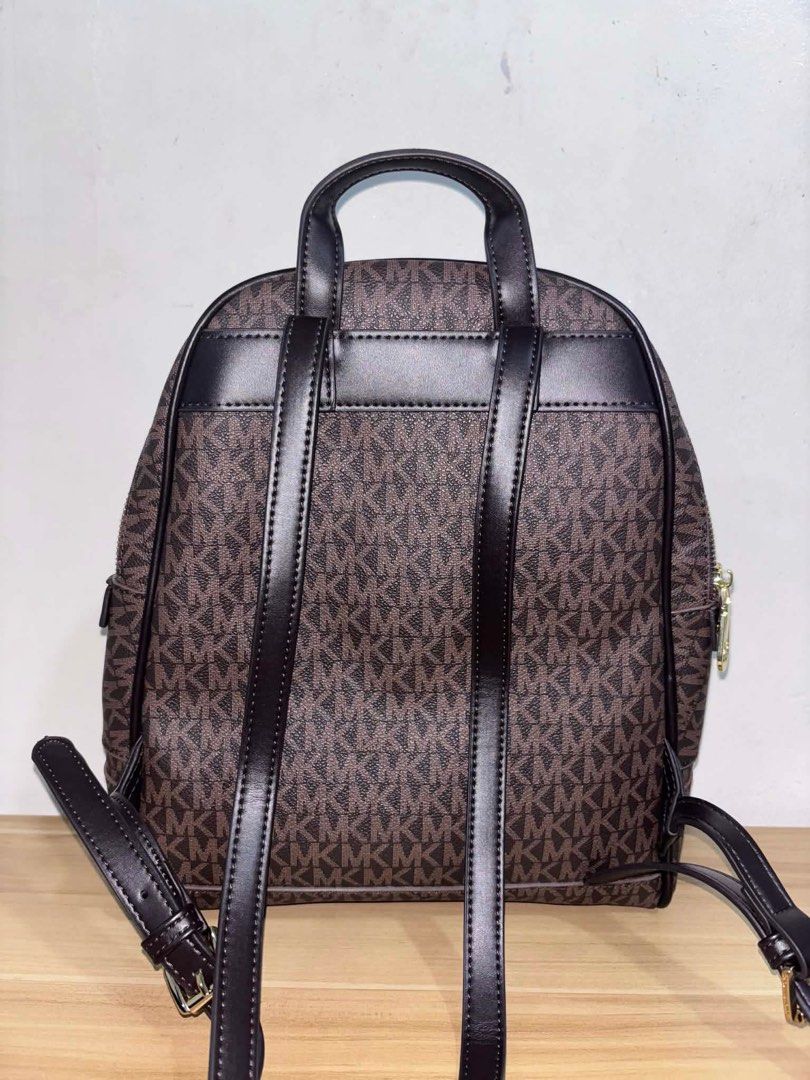 Michael Kors Rhea Backpack Brown (Category: Backpacks) located in Angeles City. Submitted by cullengray (Listing ID 1469469487, Image 2). Description: Signature Logo Backpack Brown Crafted from logo-print coated canvas with durable trim and gold-tone hardware; features a YKK zip closure made in Vietnam. • Secured zip fastening with a fully lined polyester interior for everyday organization. • Designed with a front exterior zip pocket and an inter