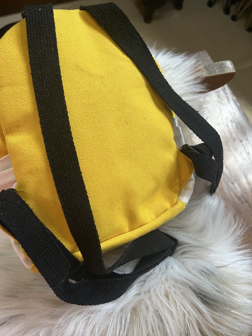 Mihua & Doudou Yellow Chick Backpack (Category: Backpacks) located in Rizal. Submitted by safecat_3c0d85 (Listing ID 1469431366, Image 3). Description: - Color: Bright Yellow - Material: Durable canvas - Design: Cute chick graphic with "Mihua & Doudou" text - Features: Front pocket with a clear display window under the flap, top grab handle, and black shoulder straps - Size: Compact and lightweight, perfect for daily casual outings and carrying s