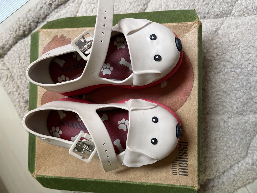 Mini Melissa Dog Shoes Toddler Size 7 (Category: Babies & Kids Fashion) located in Cavite. Submitted by sjlav (Listing ID 1469468236, Image 2). Description: - Authentic Mini Melissa toddler shoes made in Brazil - Cream and red colorway with adorable puppy face design and 3D floppy ears - Fun bone and paw print pattern on the red insoles - Secure and adjustable ankle strap with buckle closure - Includes original green and brown box .