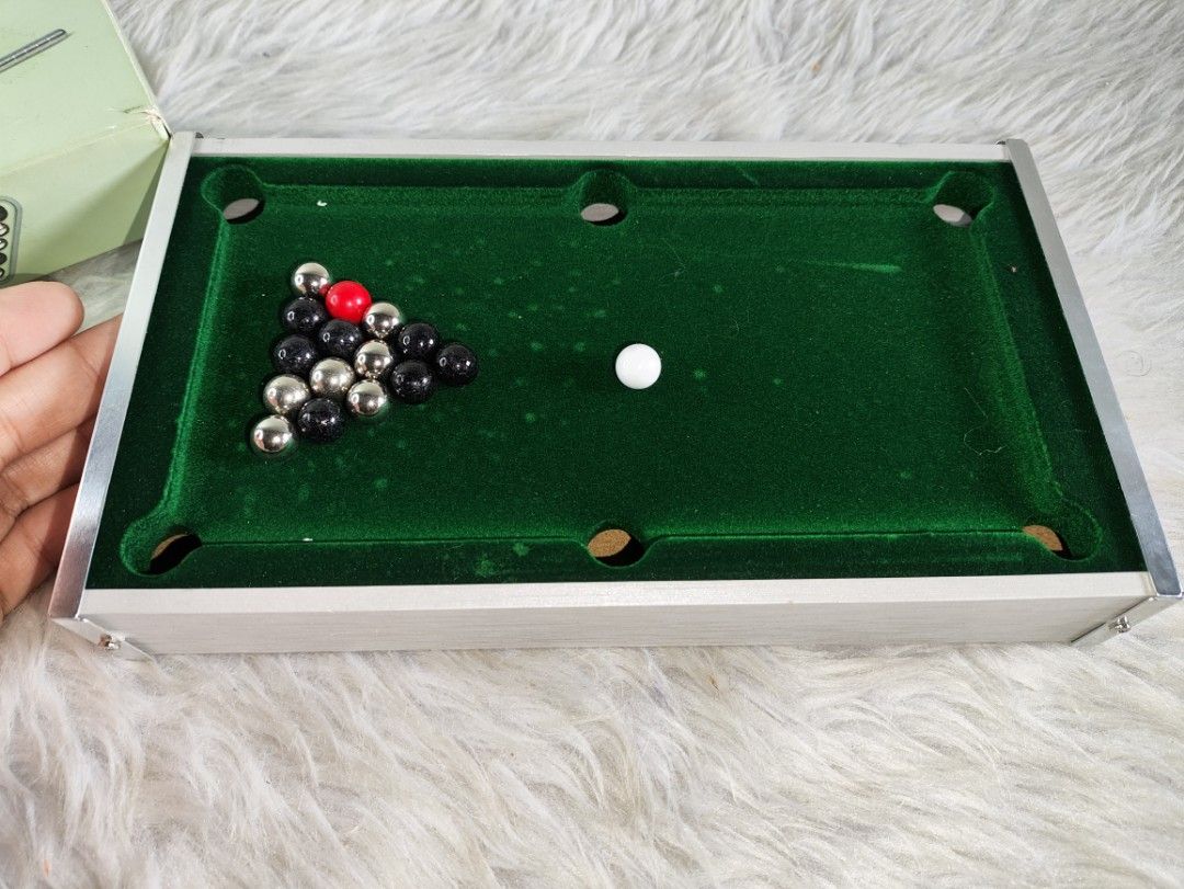 Mini tabletop pool board table game with cues and balls (Category: Board Games & Puzzles) located in Cavite. Submitted by tinetaclesss (Listing ID 1469497566, Image 2). Description: - Mini tabletop pool table with a classic green felt surface and durable aluminum frame - Compact and portable design, perfect for office desks, game nights, or casual play - Complete set includes: all playing balls, white cue ball, triangle rack, and two metal pool c