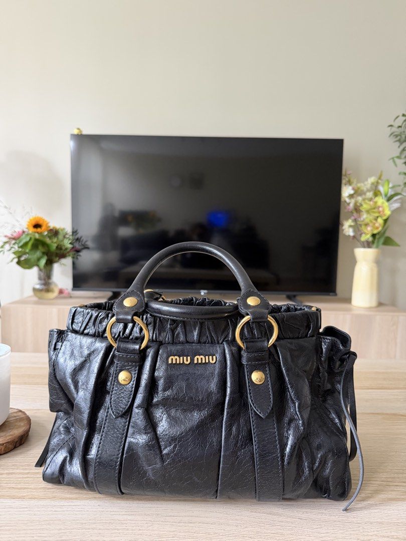 Miu Miu Vitello Bag (Category: Luxury Bags & Wallets) located in Marikina City. Submitted by hazeljaner (Listing ID 1469485220, Image 1). Description: This is a vintage Miu Miu Vitello Lux Gathered Tote in black leather, featuring signature gathered (ruched) details, gold-tone hardware, rolled top handles, and the embossed Miu Miu logo on the front. It doesn’t come with a strap. This is open for layaway for 3 months. I require 30% downpayment whi