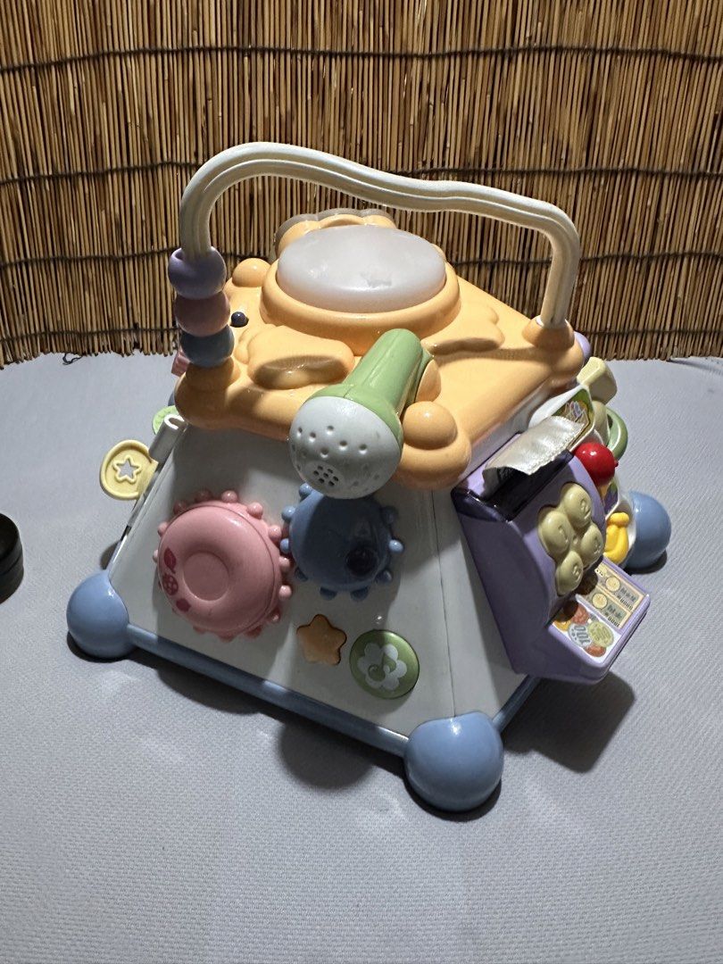 Multi-activity baby learning cube toy with music and games (Category: Infant Playtime) located in Cainta. Submitted by mochimochiko (Listing ID 1469417263, Image 1). Description: -As Is. WYSIWYG - Multi-sided interactive learning toy for toddlers - Features a built-in microphone, cash register, sliding elements, beads, and buttons on every side - Bright and colorful design to keep young kids engaged - Convenient top handle for easy carrying.