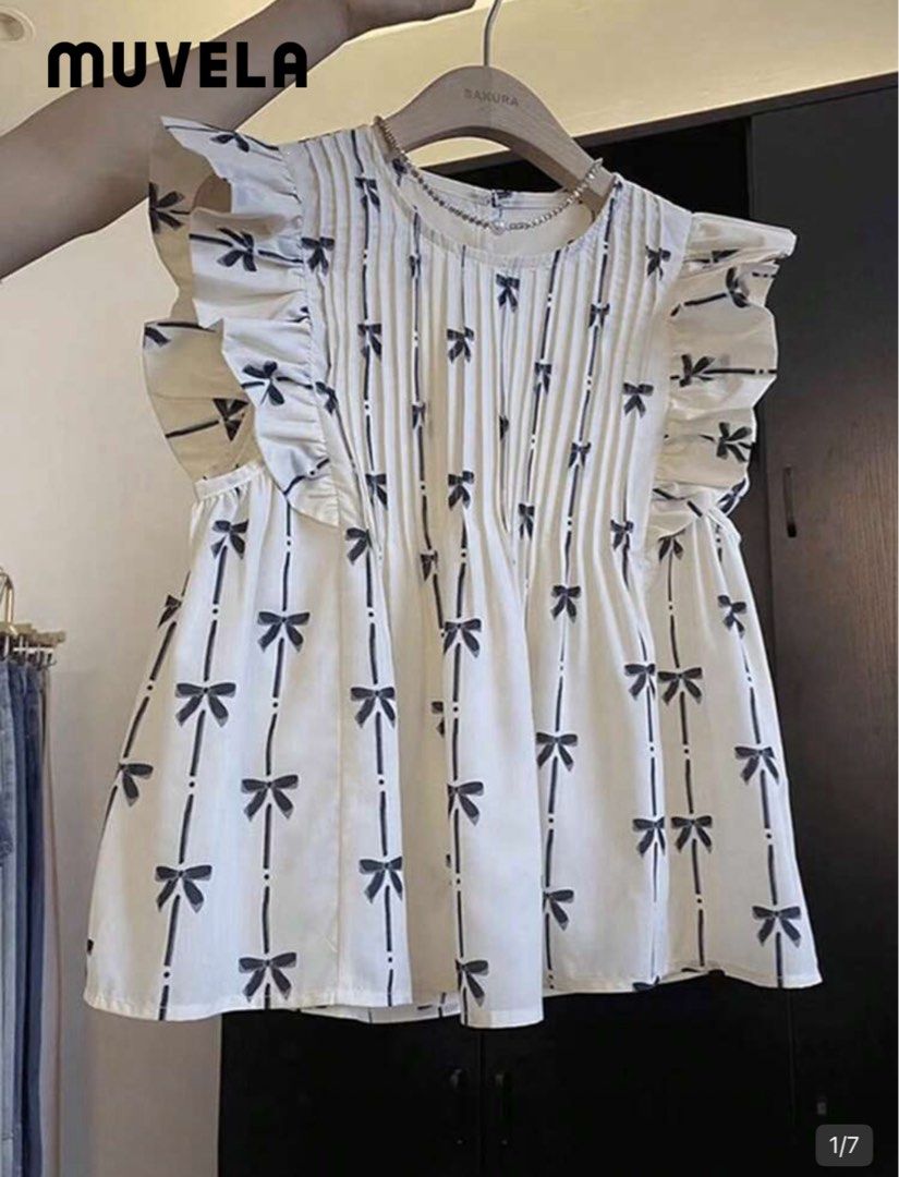 Muvela White Bow Print Pleated Blouse (Category: Blouses) located in Pasig City. Submitted by lai028 (Listing ID 1469534967, Image 1). Description: selling coz it’s big on me - best fit medium - Brand: Muvela - Color: Off-white with black ribbon stripes - Details: Ruffled cap sleeves, round neckline, back button closure, and flowy pleated fabric - Condition: Excellent pre-loved condition - Styling tip: Pairs perfectly with light wash denim for a 
