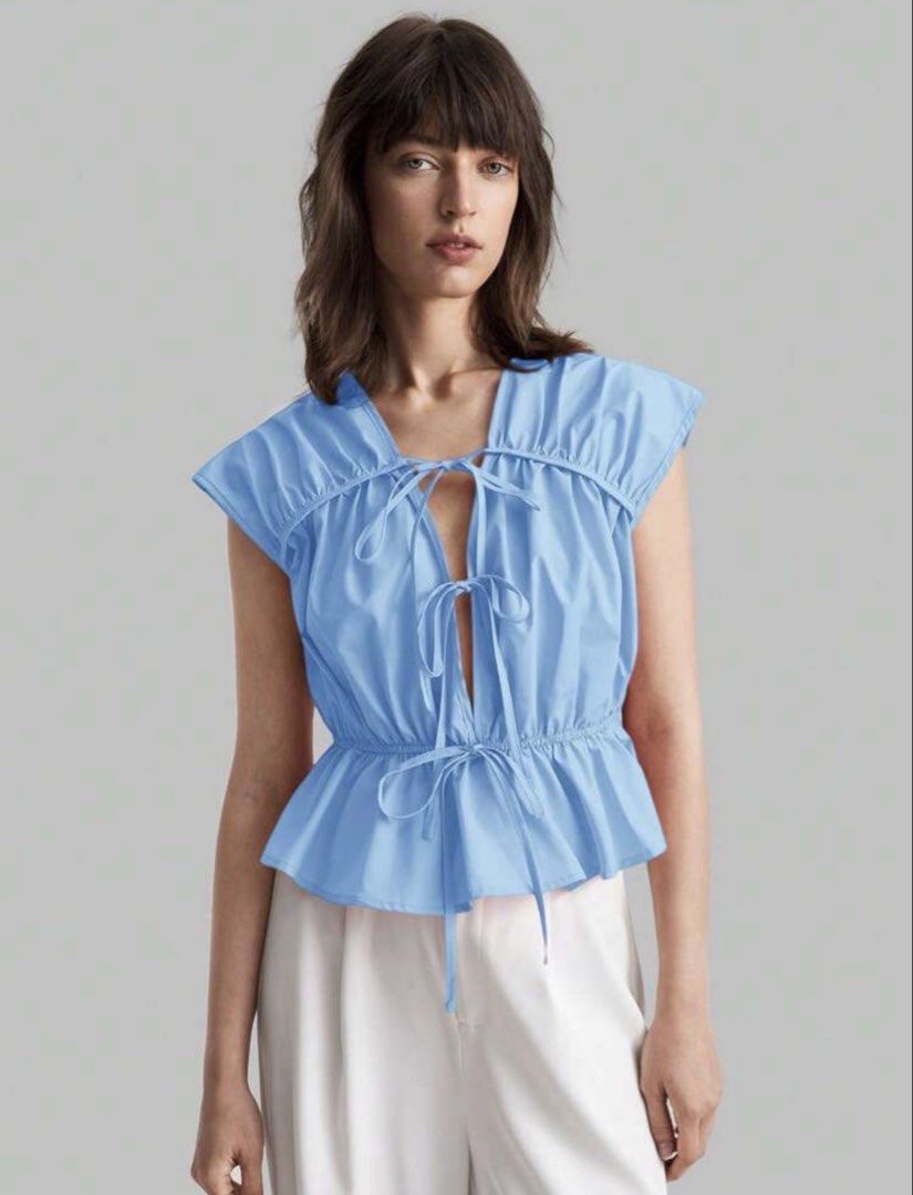 Navy Blue Tie-front Peplum Blouse (Category: Sleeveless) located in Mandaluyong City. Submitted by blzstr (Listing ID 1469430938, Image 2). Description: - Size small but fits medium nicely since garterized yung waist - Color: Navy blue - Multiple tie-front closures, cap sleeves with gathered shoulder/back details - Fitted waist with flared peplum hem - used once.