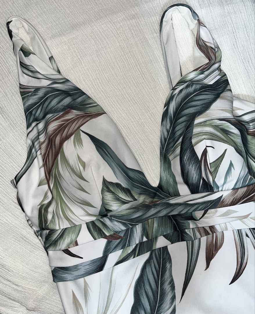 NEXT Botanical Leaf Print One Piece Swimsuit (Category: Bikinis & Swimsuits) located in General Mariano Alvarez. Submitted by kascade (Listing ID 1469536241, Image 3). Description: - Brand: Next - Style: One-piece swimsuit with V-neckline and twisted front detail - Color/Pattern: Green botanical leaf print on a crisp white background - Support: Built-in padded cups for shape and comfort - Coverage: Standard brief cut on the bottom - Size: L 💵 Pa