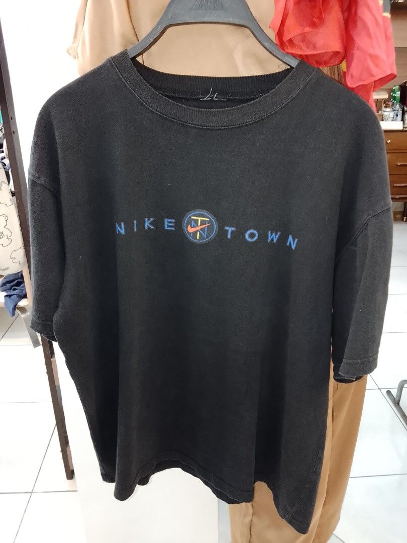 Nike 1990s Nike town Graphic tee (Category: Tshirts & Polo Shirts ) located in Manila. Submitted by newage.vintage (Listing ID 1469479908, Image 1). Description: - Brand: Nike - Color: Faded black/ Sun faded charcoal giving it an authentic vintage aesthetic - Fit: Relaxed/ Boxy vintage fit - Tag is missing / cut - vintage condition - Dimes 27X22.