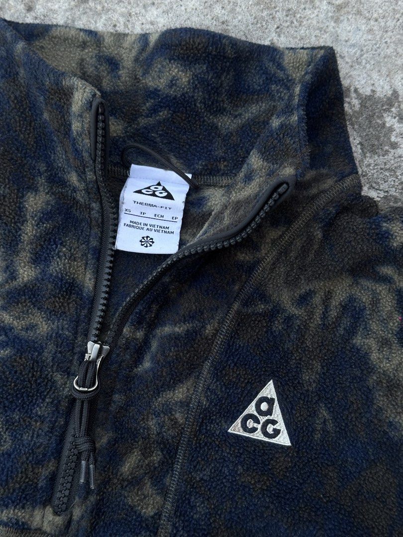 Nike ACG Wolf Tree Therma-FIT Fleece Pullover XS (Category: Coats, Jackets and Outerwear) located in Bago City. Submitted by thekasproject (Listing ID 1469477270, Image 2). Description: - Brand: Nike ACG - Model: Wolf Tree Half-Zip Fleece Pullover (Style DJ1276-437) - Color: Blue and dark grey camouflage - Size: XS - Material: Warm and lightweight Polartec fleece - Features: High collar with zip closure, embroidered ACG triangle logo on chest, zi