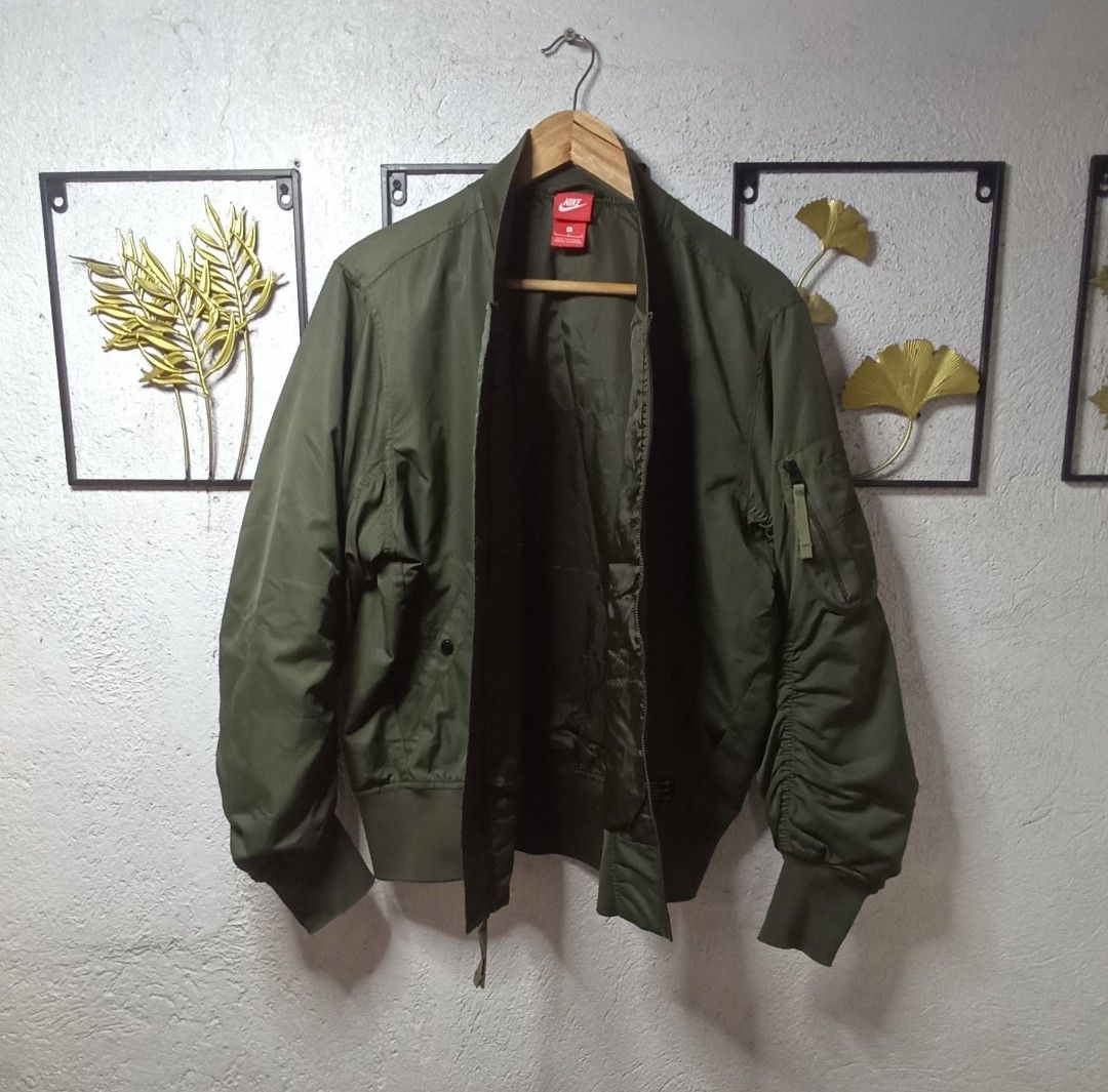 Nike Air Force 1 MA-1 Bomber Jacket (Category: Coats, Jackets and Outerwear) located in Kawit. Submitted by deidzdzn (Listing ID 1469456867, Image 3). Description: - Brand: Nike - Style: AF-1 MA-1 Bomber Jacket - Color: Olive Green - Size: Large (L) with a trendy boxy fit - Details: Ribbed collar, cuffs, and hem; front zipper closure; slip hand pockets; zippered utility pocket on left sleeve - Branding: Tonal Nike logo embroidered on left chest -