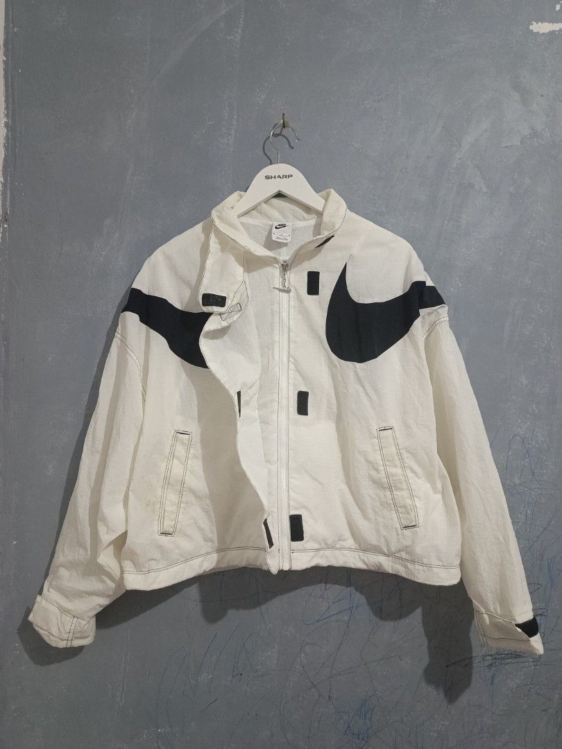 Nike Big Swoosh White Black Windbreaker Jacket (Category: Coats, Jackets and Outerwear) located in Iloilo. Submitted by wendxcz-thrift- (Listing ID 1469504074, Image 1). Description: - Brand: Nike - Style: White nylon windbreaker jacket - Design: Big black swoosh logos wrapping around shoulders and chest - Details: Stand-up collar, silver swoosh zipper pull, side pockets, mesh lining, and drawcord hem - Size: M - Origin: Made in China NEEDS WASH 