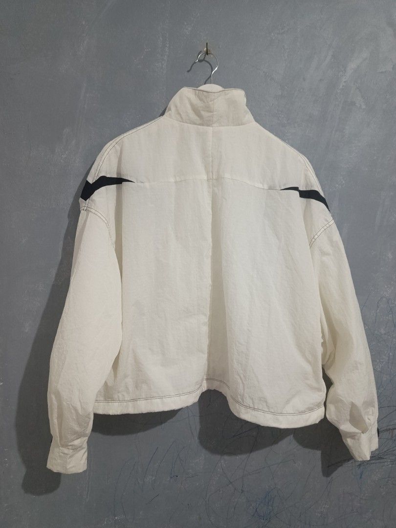 Nike Big Swoosh White Black Windbreaker Jacket (Category: Coats, Jackets and Outerwear) located in Iloilo. Submitted by wendxcz-thrift- (Listing ID 1469504074, Image 3). Description: - Brand: Nike - Style: White nylon windbreaker jacket - Design: Big black swoosh logos wrapping around shoulders and chest - Details: Stand-up collar, silver swoosh zipper pull, side pockets, mesh lining, and drawcord hem - Size: M - Origin: Made in China NEEDS WASH 