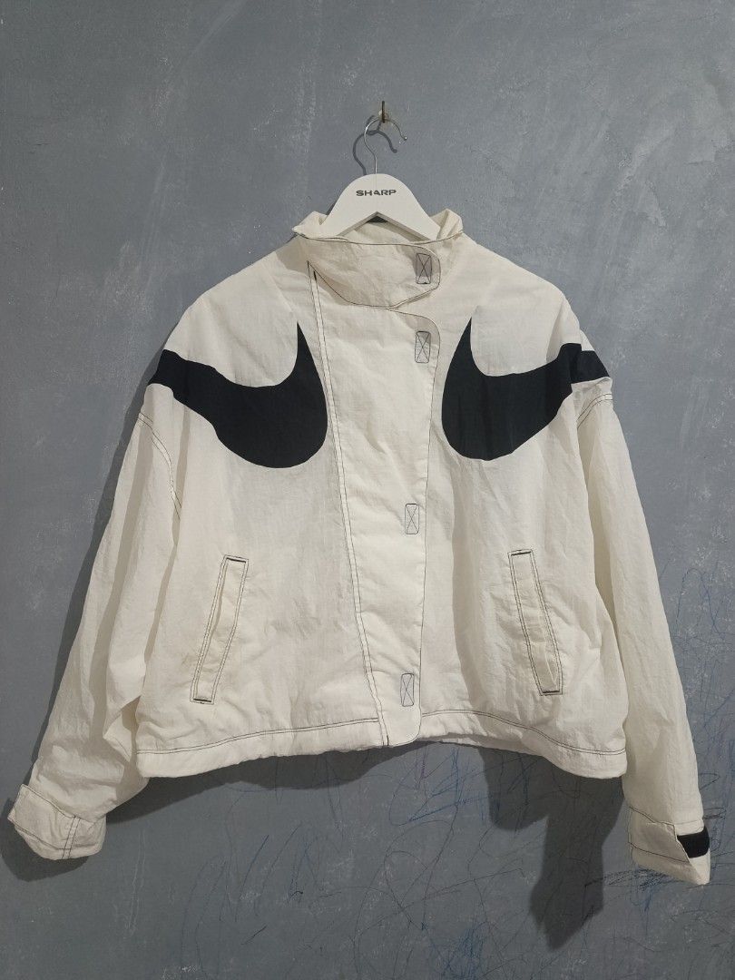 Nike Big Swoosh White Black Windbreaker Jacket (Category: Coats, Jackets and Outerwear) located in Iloilo. Submitted by wendxcz-thrift- (Listing ID 1469504074, Image 2). Description: - Brand: Nike - Style: White nylon windbreaker jacket - Design: Big black swoosh logos wrapping around shoulders and chest - Details: Stand-up collar, silver swoosh zipper pull, side pockets, mesh lining, and drawcord hem - Size: M - Origin: Made in China NEEDS WASH 