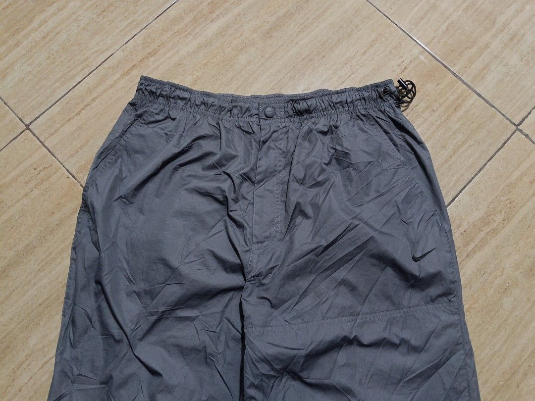 Nike Gray Nylon Track Pants Windbreaker Pants (Category: Joggers) located in Glan. Submitted by cpaharodde48008 (Listing ID 1469503499, Image 3). Description: - Authentic Nike gray nylon track pants - Lightweight windbreaker material, perfect for PH weather - Elastic waistband with adjustable drawstring toggle - Snap button closure on the waist - Embroidered black Swoosh logo on the front left leg - Stylish paneled leg design - Convenient back zi