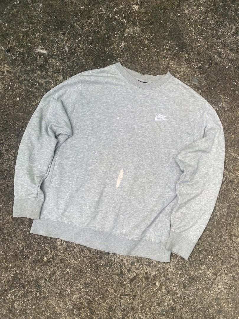 Nike Grey Crewneck Sweatshirt with Small Logo (Category: Coats, Jackets and Outerwear) located in Quezon City. Submitted by jaredalvarr (Listing ID 1469480571, Image 1). Description: - Brand: Nike - Item: Grey crewneck sweatshirt - Details: Small white embroidered swoosh on the chest, ribbed cuffs and hem - Flaws: Noticeable bleached stains down the front middle area and a small spot above it - Condition: Super comfy, ideal for casual wear or laz