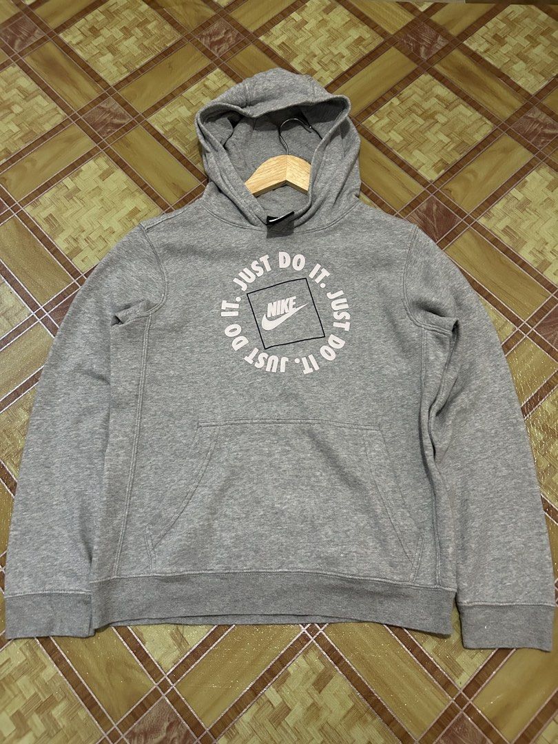 Nike Just Do It Grey Hoodie Size L (Category: Hoodies) located in Manila. Submitted by garmentfinds.01 (Listing ID 1469520963, Image 2). Description: - Authentic grey Nike pullover hoodie - Bold 'Just Do It' circular graphic on the front - Classic kangaroo pocket and standard fit - Size L (Tag indicates fit for ages 12 to 13) - Material: 80% cotton, 20% polyester body; 100% cotton hood lining - Warm, soft, and comfortable for daily use - Made in 