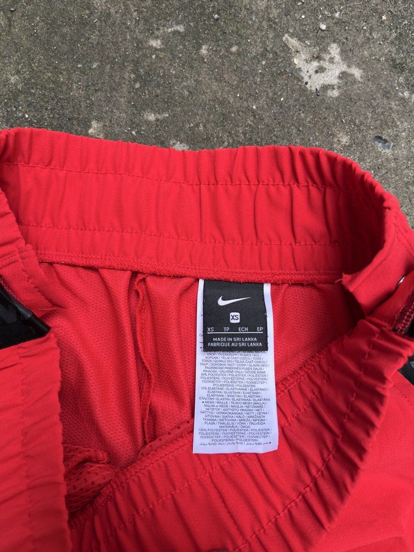 Nike Pro Red Side Snap Track Pants (Category: Joggers) located in Manila. Submitted by thrifttika (Listing ID 1469448960, Image 1). Description: Bright red Nike Pro warm-up pants. Black side taping reads Nike Pro repeatedly. Metal snap buttons run down both outer legs. Elastic waistband with a small silver Swoosh logo front and center. Size extra small tag attached inside. Made in Sri Lanka from polyester and elastane blend material. Lightweight 