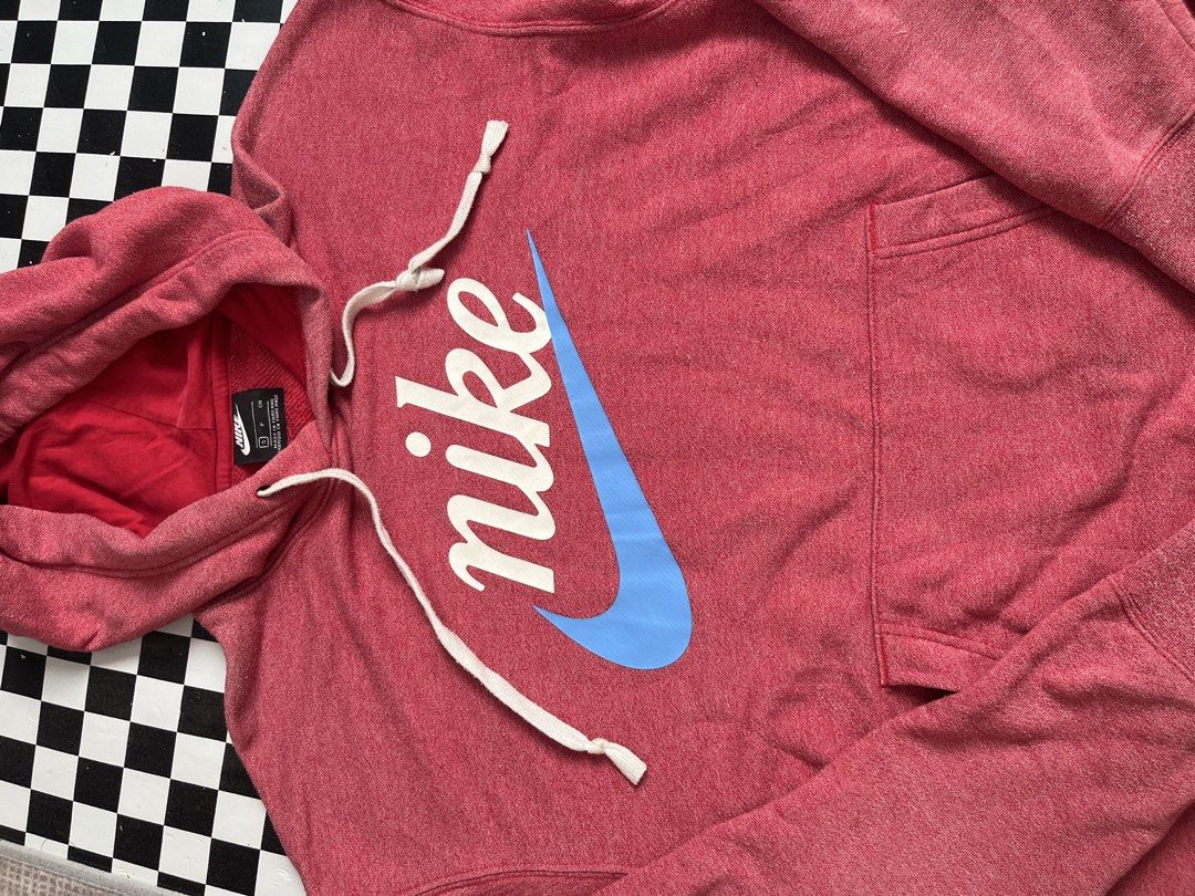Nike Red Blue Script Logo Pullover Hoodie (Category: Hoodies) located in Manila. Submitted by joebertbar04956 (Listing ID 1469449535, Image 3). Description: - Brand: Nike - Size: S (tag on collar) - Color: Red heathered with contrast blue swoosh and white lettering - Design: Large script logo across the chest, adjustable drawstring hood with red interior lining - Features: Front kangaroo pocket, ribbed cuffs and hem - Material: Cotton and polyest