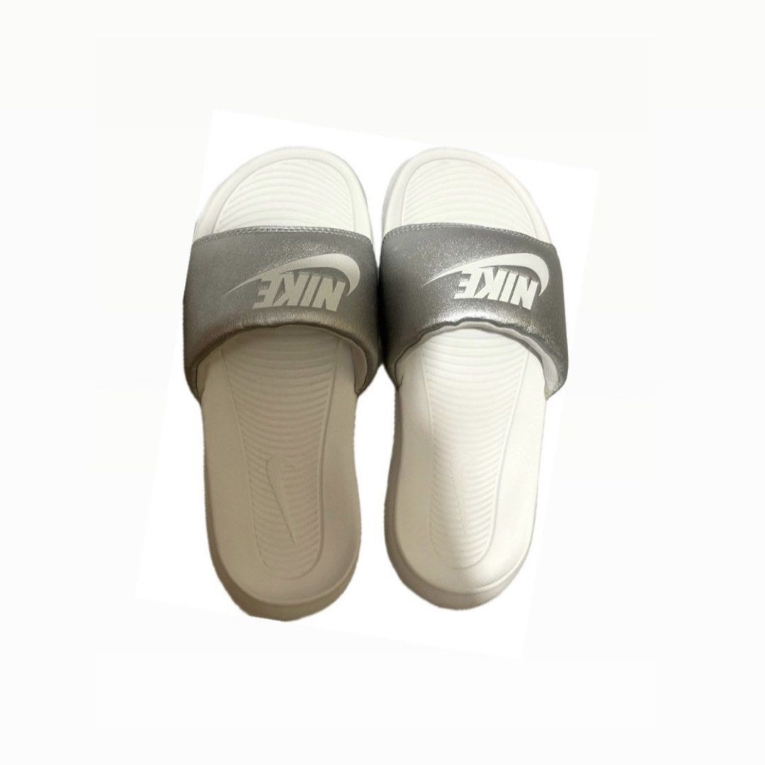 Nike Slides White Silver (Category: Slippers and slides) located in Quezon City. Submitted by hpgrl (Listing ID 1469407250, Image 1). Description: SALE! - Brand: Nike - Style: Slip-on slides - Color: White footbed with metallic silver strap and white swoosh - Features: Super comfortable cushioning and textured grip pattern - Condition: Clean, great daily wear for errands or the pool, ready to wear.