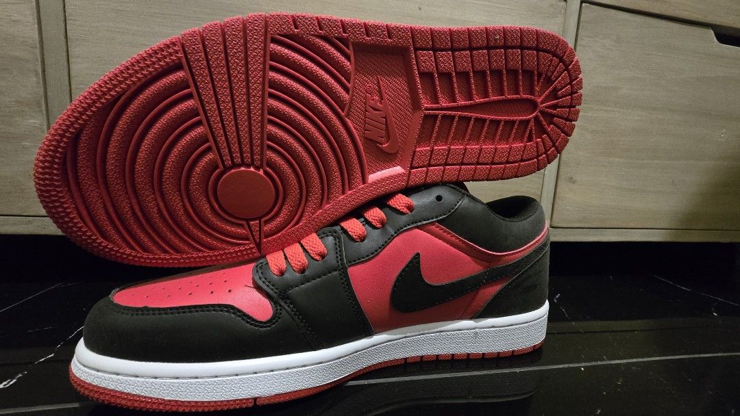 Nike US size 9.5 (Category: Sneakers) located in Quezon City. Submitted by ShoesManila (Listing ID 1469538934, Image 1). Description: Nike US size 9.5 men Air Jordan 1 Low sneakers in red and black colorway. Classic leather upper, perforated toe box, signature Swoosh branding on the sides. Jumpman logo on the tongue, embroidered Wings logo on the heel counter. White midsole paired with red rubber outsole for traction. Extra laces included in a pl