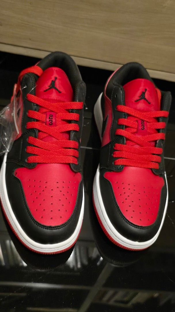 Nike US size 9.5 (Category: Sneakers) located in Quezon City. Submitted by ShoesManila (Listing ID 1469538934, Image 2). Description: Nike US size 9.5 men Air Jordan 1 Low sneakers in red and black colorway. Classic leather upper, perforated toe box, signature Swoosh branding on the sides. Jumpman logo on the tongue, embroidered Wings logo on the heel counter. White midsole paired with red rubber outsole for traction. Extra laces included in a pl