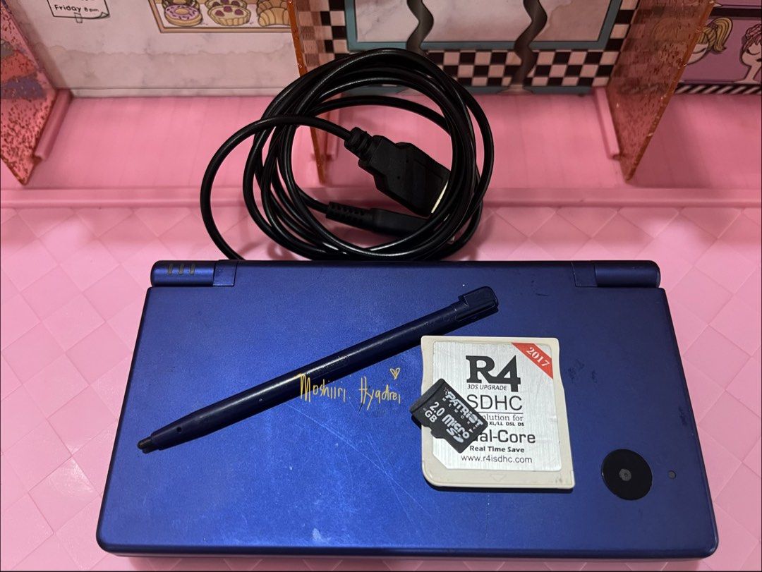Nintendo DSi - Metallic Blue (Category: Nintendo) located in Valenzuela. Submitted by moshiiri_kawaii_v2 (Listing ID 1469549733, Image 1). Description: Nintendo DSi - Metallic Blue Working touch screen, buttons and dual cameras, Seems not yet repaired - Intact sticker warranty With 25 games installed Goods battery life Inclusion : Unit, R4 with 2gb microsd, orig stylus, replacement power cord (adaptor not included) Flaws: minimal scratches, Scree
