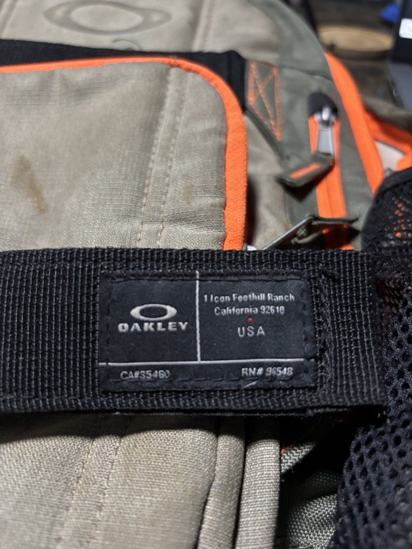 Oakley Olive Green Backpack with Orange Accents (Category: Backpacks) located in Manila. Submitted by markjoy712 (Listing ID 1469400458, Image 2). Description: - Authentic Oakley backpack in olive green with striking bright orange trim - Features iconic Foothill Ranch, California logo patch and black utility straps - Equipped with multiple zippered compartments and convenient mesh side pockets - Dual horizontal strapping system for extra gear and