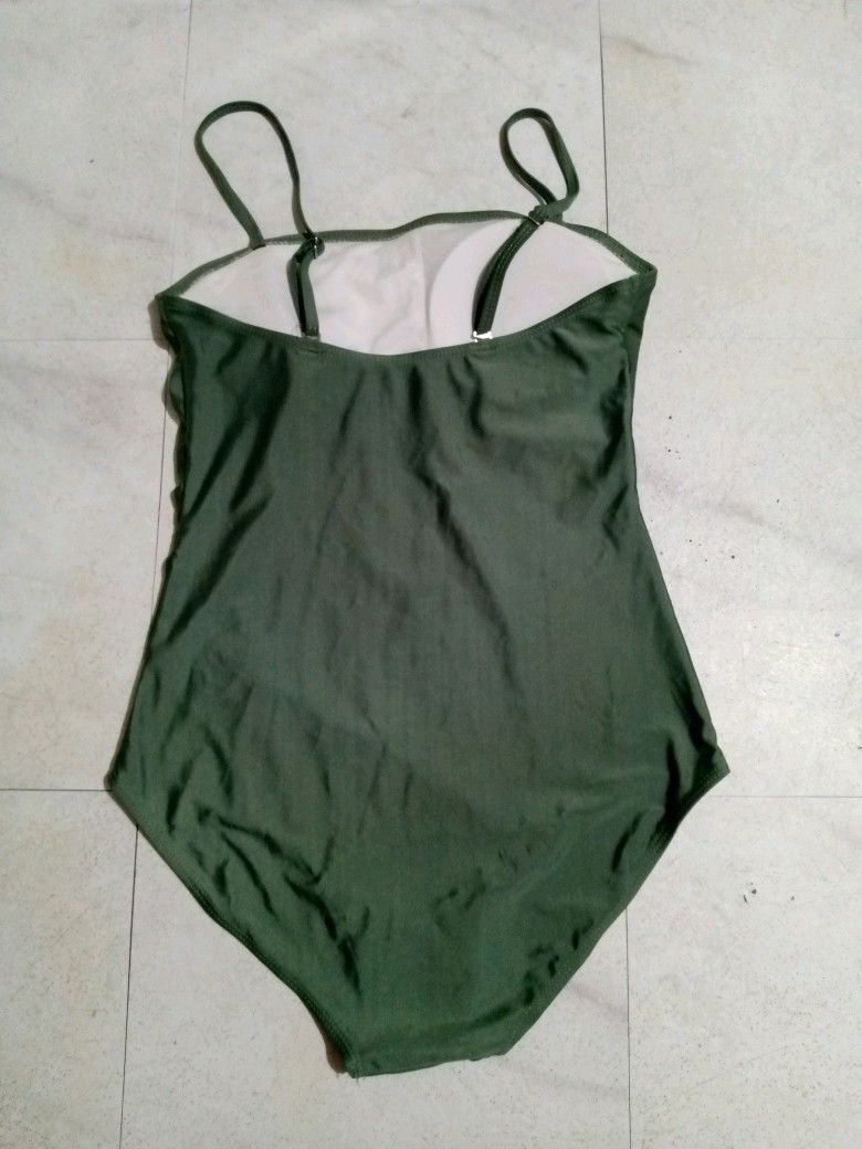 Olive Green bodysuit, stretchy M-L size (Category: Sleeveless) located in Taguig. Submitted by anika_francine (Listing ID 1469493452, Image 2). Description: - Color: Army Green - Design: Simple solid color one-piece - Straps: Thin and adjustable with metal sliders - Cut: Straight neckline and moderate leg cut - Support: Built-in chest padding - Material: Smooth, stretchy fabric with clean inner lining.