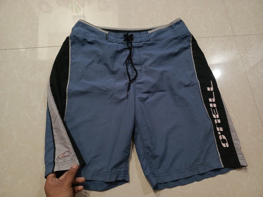 O'Neill Board Shorts Blue Black Surf Trunks (Category: Swim Trunks & Board Shorts) located in Cabatuan. Submitted by penthegreat (Listing ID 1469411441, Image 2). Description: 880+ship - Brand: O'Neill - Colorway: Blue and black with stylish grey panel accents - Logos: White brand text down the left leg and smaller logo on the lower right - Waist: Adjustable front drawstring closure - Pocket: Single back pocket with secure flap and logo tab - Fit