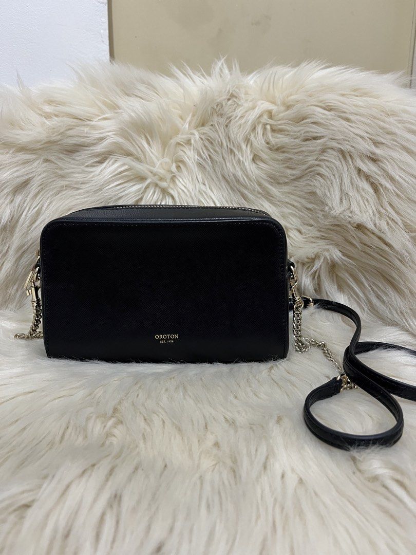 Oroton Black Crossbody Camera Bag with Chain Strap (Category: Cross-body Bags) located in Naga. Submitted by ownlineshopp (Listing ID 1469504209, Image 3). Description: - Brand: Oroton - Style: Sling bag - Material: Premium pebbled leather - Color: Classic black with elegant gold-tone hardware - Closure: Secure zip top - Strap: Removable strap featuring a stylish mix of chain links and leather - Branding: Subtle gold embossed logo on the front - 