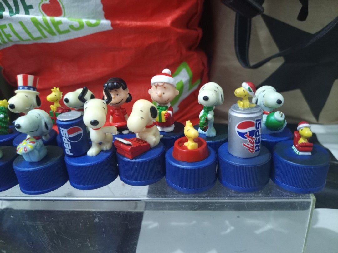 Peanuts Snoopy Christmas Pepsi Bottle Cap Figures Set (Category: Vintage Collectibles) located in Manila. Submitted by warmcrystal_269010 (Listing ID 1469550917, Image 3). Description: - Set of official Peanuts mini figures on blue Pepsi bottle caps - Features Snoopy, Charlie Brown, Woodstock, and holiday-themed gang members - Authentic promotional items with copyright stamps underneath - Sold as a complete lot, perfect for Peanuts collectors.