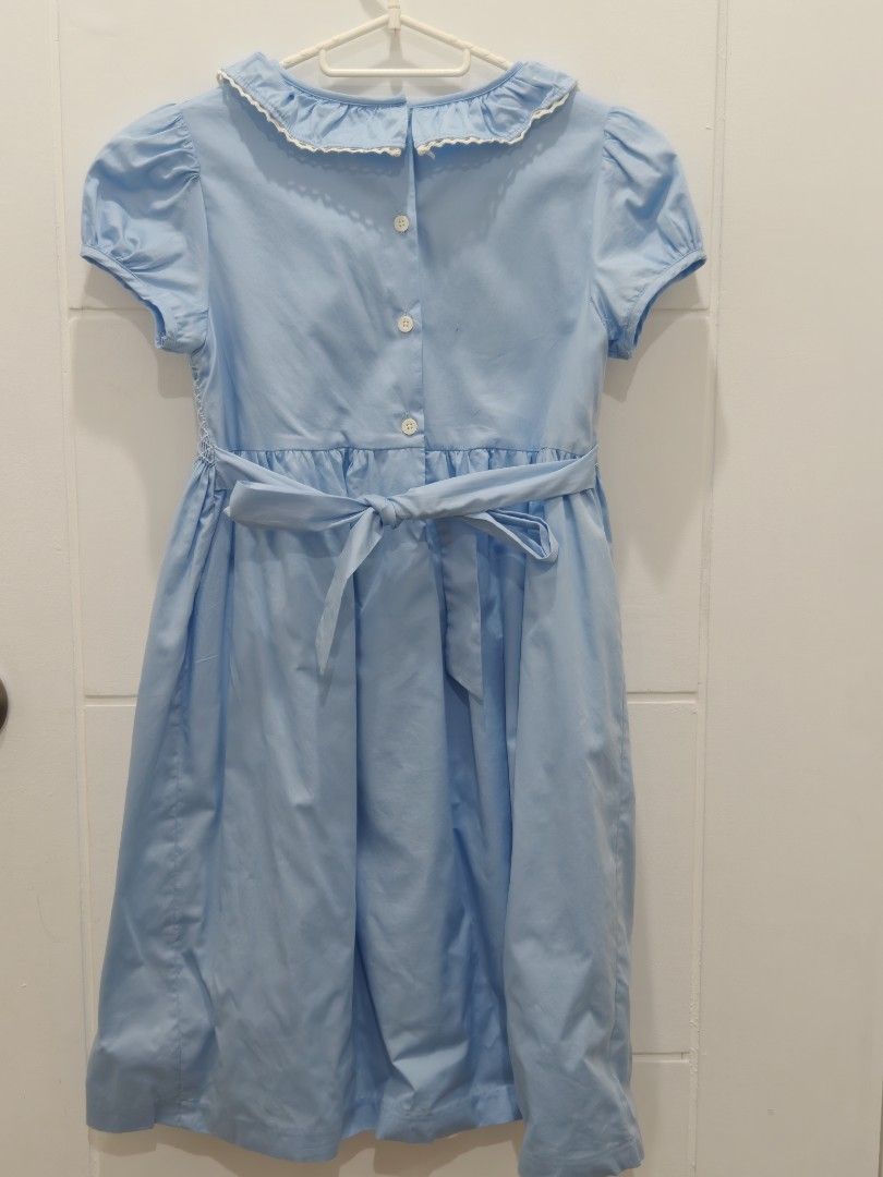 Periwinkle Blue Smocked Dress Size 12Y (Category: Babies & Kids Fashion) located in Cebu City. Submitted by periwinkletwinkles (Listing ID 1469448570, Image 2). Description: - Brand: Periwinkle - Size: 12Y (fits older kids) - Color: Light Blue - Material: 100% Cotton - Design: Smocked chest with tiny floral embroidery, white ruffled collar, and puffed short sleeves - Closure: Back buttons with a matching attached waist sash - Condition: Excellent