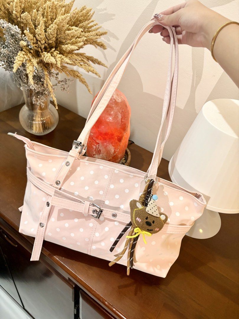 Pink Polka Dot Tote Bag with Bear Charm (Category: Tote Bags) located in Binangonan. Submitted by blairmayie (Listing ID 1469444006, Image 1). Description: - Color & Pattern: Pink with white polka dots - Closure: Secure top zipper - Included: Adorable brown bear plush keychain and decorative front buckle strap - Features: Long shoulder straps, spacious interior for daily essentials - Condition: Clean and well-maintained.