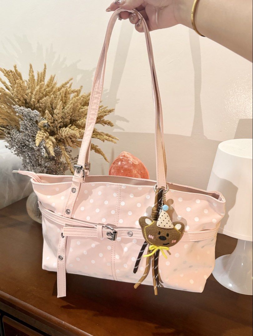 Pink Polka Dot Tote Bag with Bear Charm (Category: Tote Bags) located in Binangonan. Submitted by blairmayie (Listing ID 1469444006, Image 2). Description: - Color & Pattern: Pink with white polka dots - Closure: Secure top zipper - Included: Adorable brown bear plush keychain and decorative front buckle strap - Features: Long shoulder straps, spacious interior for daily essentials - Condition: Clean and well-maintained.