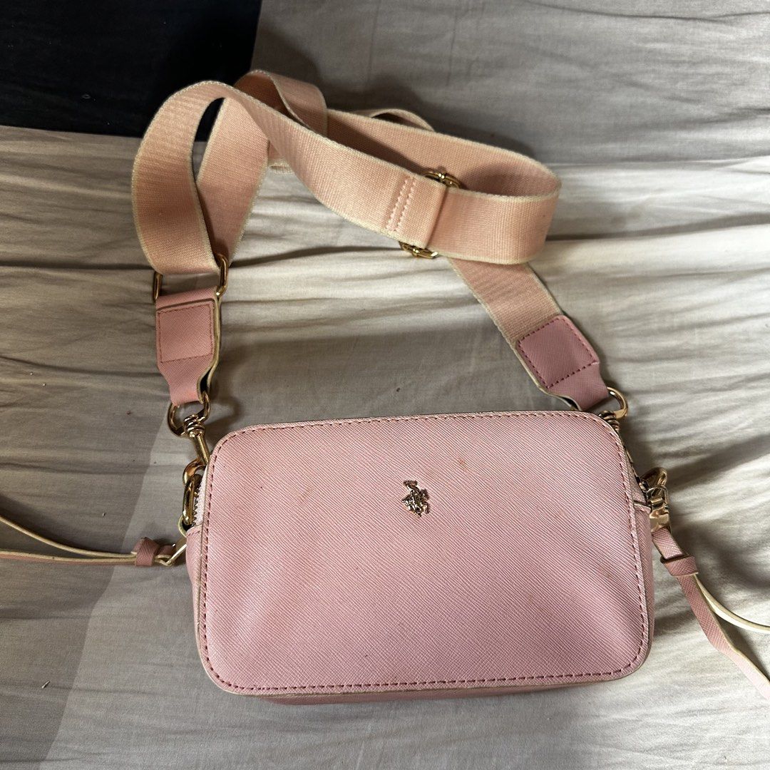 Pink Polo Crossbody Bag (Category: Cross-body Bags) located in Manila. Submitted by daintywears (Listing ID 1469449228, Image 1). Description: needs major cleaning - Color: Soft pink with elegant gold hardware - Material: Textured leather finish - Design: Compact rectangular shape with top zip closure and zipper pull extensions - Branding: Centered gold polo player logo emblem - Strap: Matching adjustable wide fabric strap with convenient swivel 