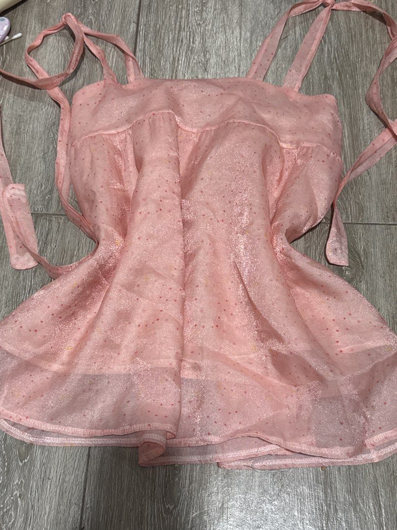 Pink Sparkly Polka Dot Cami Top With Ties (Category: Sleeveless) located in Pateros City. Submitted by sophiahipolito (Listing ID 1469522214, Image 1). Description: - Color & Material: Light pink sheer fabric with a subtle sparkle - Pattern: All-over tiny red and yellow polka dots - Straps & Sides: Adjustable ribbon tie straps at shoulders and sides - Design: Layered ruffle hem for a sweet, feminine look - Style: Lightweight and breezy, perfect f