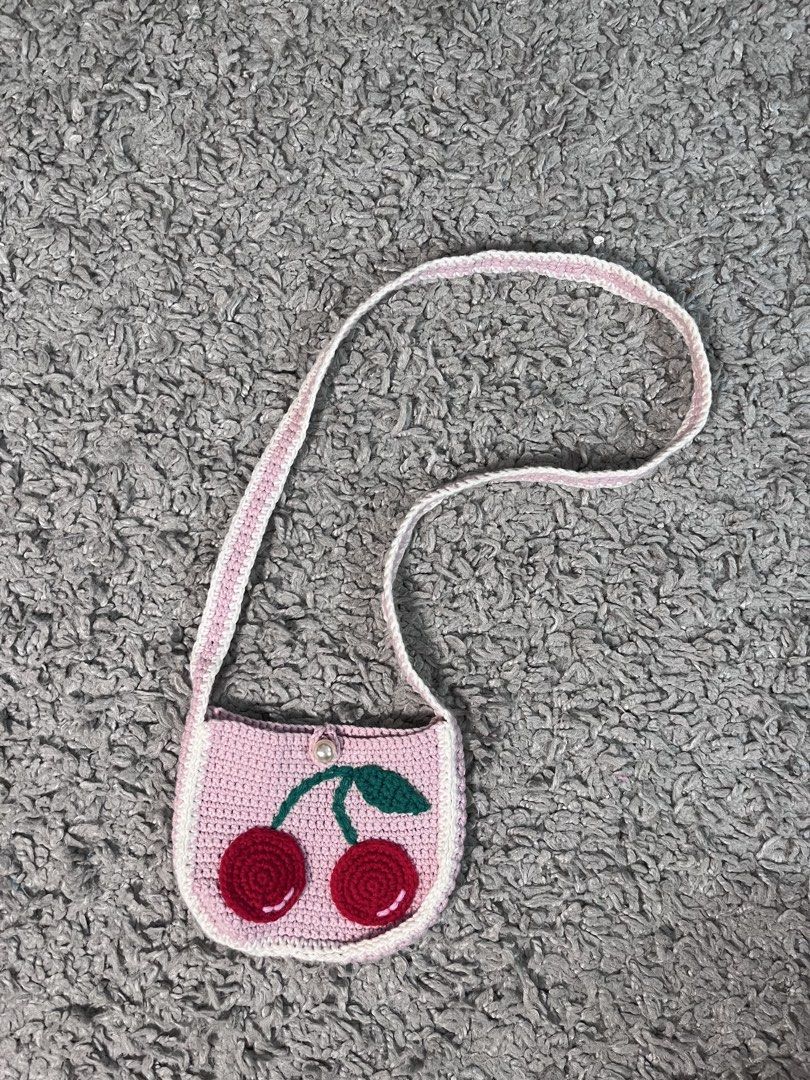 pink-knitted mini crossbody bag with cherry design (Category: Cross-body Bags) located in Davao. Submitted by fromadollscloset (Listing ID 1469435352, Image 1). Description: [READ MY BIO FIRST!] ⭐️ description ⭐️ - best for little kids tbh - the sling is short - can fit coins and other small items.