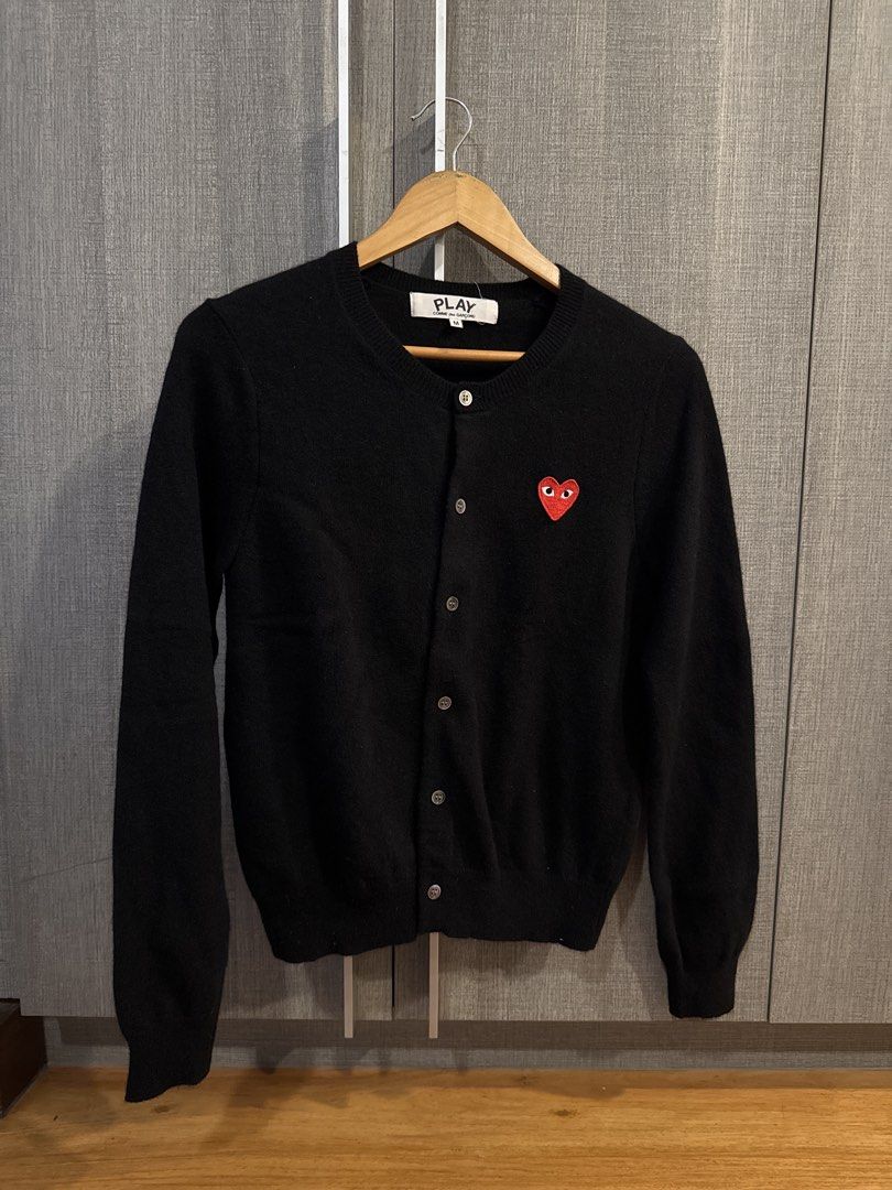PLAY Comme des Garçons Black Cardigan (Category: Coats, Jackets and Outerwear) located in Makati City. Submitted by kkk.shops (Listing ID 1469509766, Image 1). Description: - Brand: PLAY Comme des Garçons - Item: Black knit cardigan - Size: Medium (M) - Details: Signature red heart patch, round neckline, button-down front, long sleeves, ribbed cuffs and hem - Condition: Like new, worn only a couple of times and carefully stored - 100% authentic a